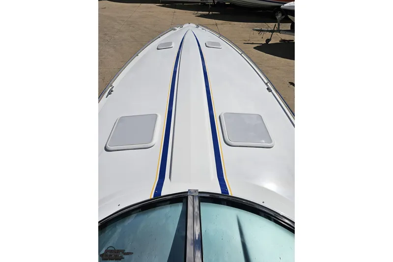 Slide: The Image of 2012 Formula 382 FASTech boat deck with blue and yellow stripes, docked on concrete. - 53