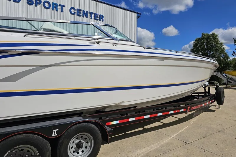 Slide: The Image of 2012 Formula 382 FASTech boat on trailer at a sport center, under a clear blue sky. - 8