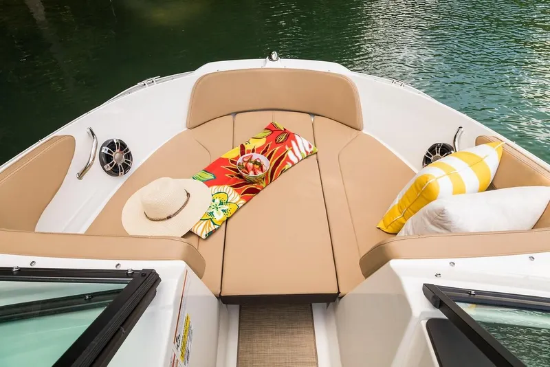Slide: The Image of 2019 Sea Ray SPX 210 OB boat interior with tan seating, colorful towel, and pillows. - 27