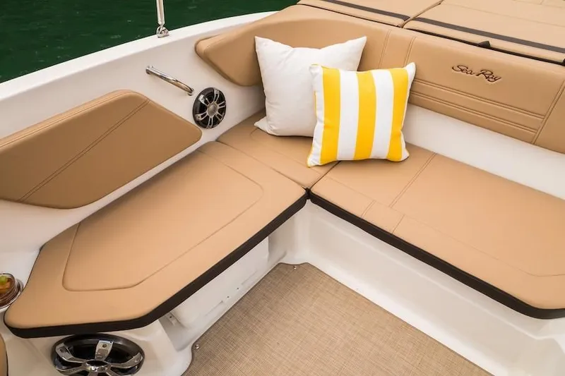 Slide: The Image of 2019 Sea Ray SPX 210 OB boat interior with tan seating and decorative pillows. - 34