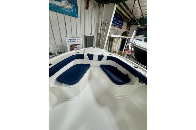 Slide: The Image of 2026 Parker 23SE Center Console boat interior with blue seating in a showroom. - 10