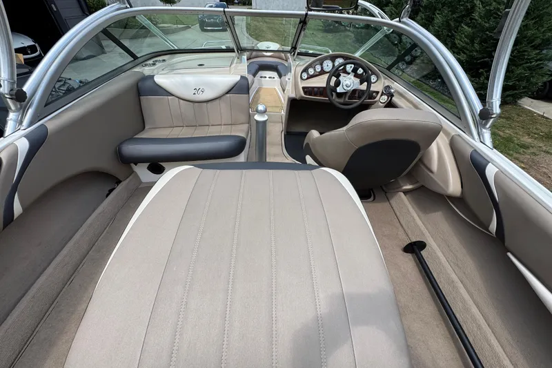 Slide: The Image of 2002 MasterCraft ProStar 209 interior with beige upholstery and sleek dashboard design. - 10