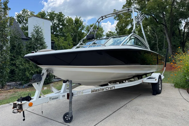 Slide: The Image of 2002 MasterCraft ProStar 209 boat on trailer, parked outdoors with trees in background. - 6
