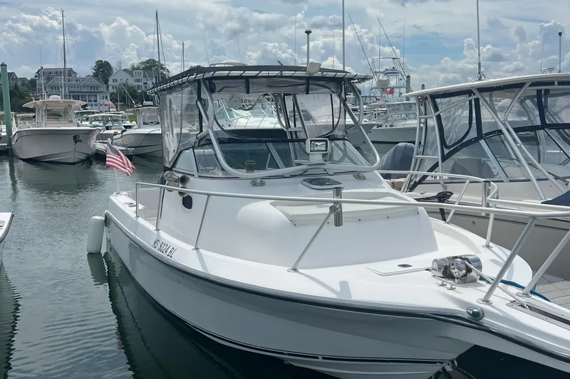 Slide: The Image of 2002 Angler 2500 WA boat docked in a marina with other vessels. - 1