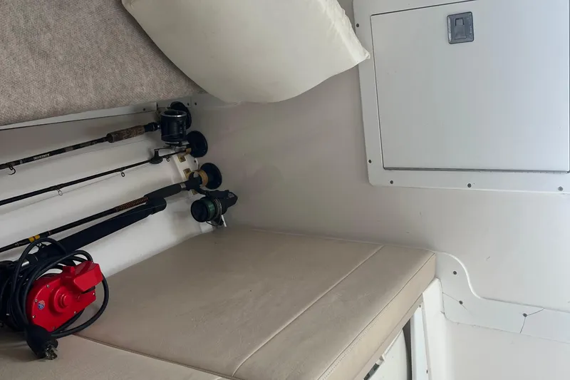 Slide: The Image of Interior of a 2002 Angler 2500 WA boat with fishing rods and storage. - 11