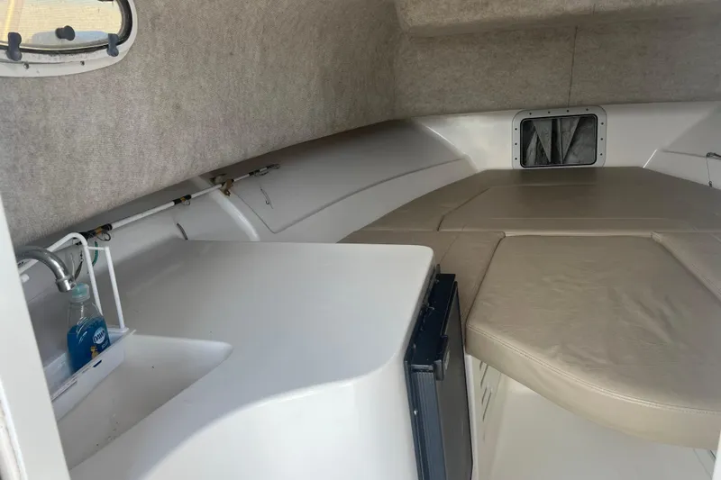 Slide: The Image of 2002 Angler 2500 WA cabin interior with sink, counter, and cushioned seating area. - 14
