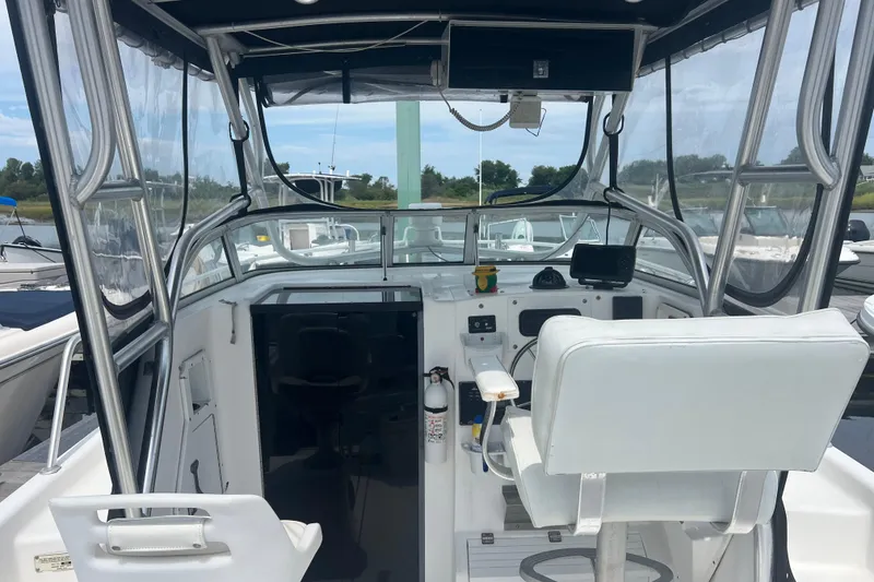 Slide: The Image of 2002 Angler 2500 WA boat cockpit with steering wheel and navigation equipment. - 5