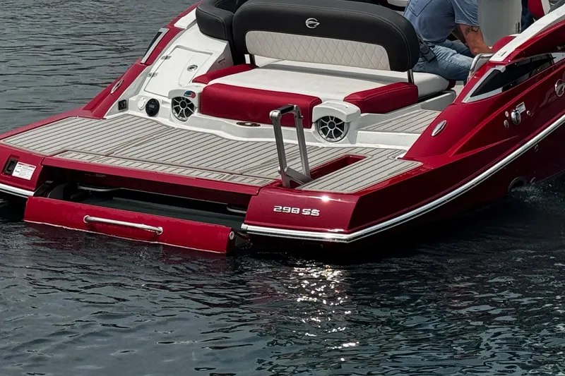 Slide: The Image of 2026 Crownline 298 SS boat with red and white seating on water. - 11