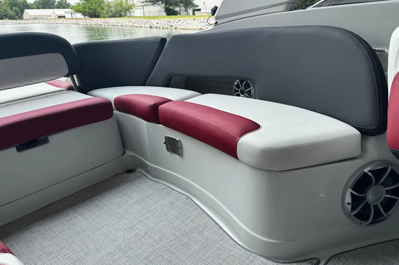 Slide: The Image of 2026 Crownline 298 SS boat interior with red and white seating, near water. - 5