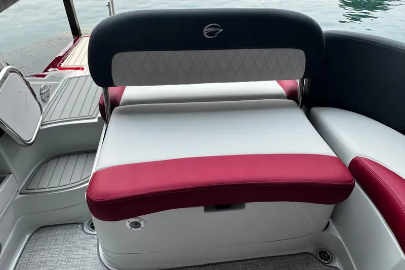 Slide: The Image of 2026 Crownline 298 SS boat interior with red and white seating, near water. - 6