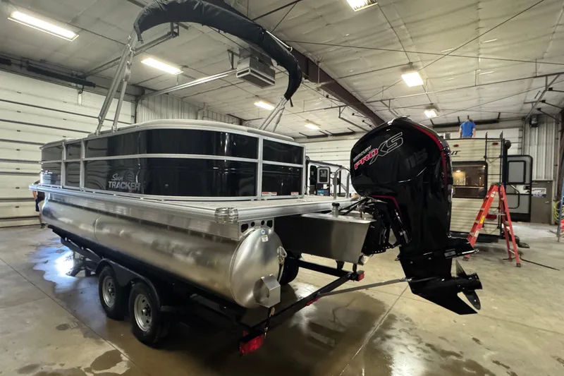 Slide: The Image of 2026 Sun Tracker Party Barge 20 DLX pontoon boat in a garage with Mercury Pro XS engine. - 5