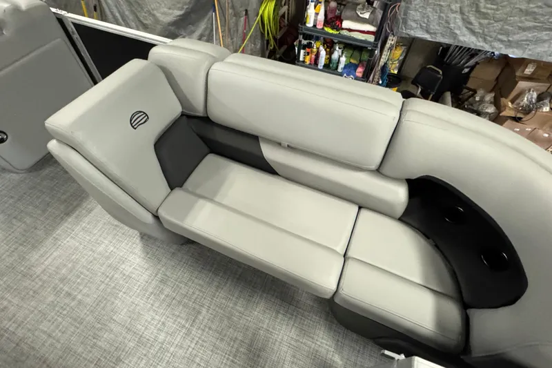 Slide: The Image of 2026 Sun Tracker Party Barge 20 DLX interior with gray seating and cup holders. - 9