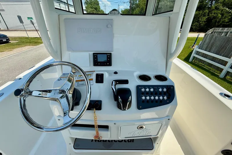 Slide: The Image of 2022 NauticStar 251 Hybrid boat console with steering wheel and control panel. - 11