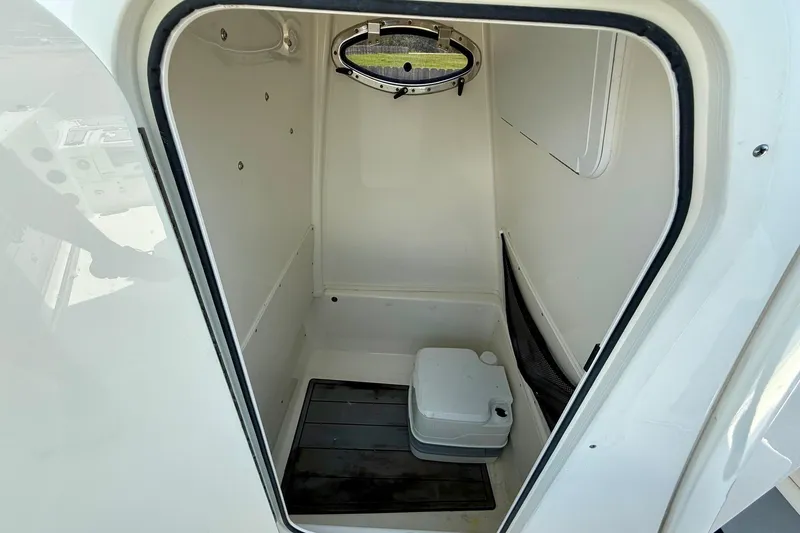 Slide: The Image of 2022 NauticStar 251 Hybrid boat interior with compact marine toilet. - 14