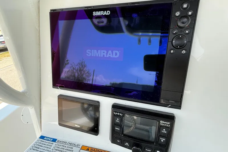 Slide: The Image of Simrad display and controls on 2022 NauticStar 251 Hybrid boat dashboard. - 18