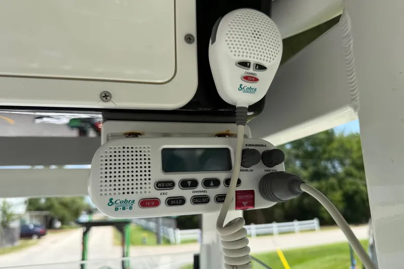 Slide: The Image of Cobra Marine radio on 2022 NauticStar 251 Hybrid boat, featuring channel controls and microphone. - 19