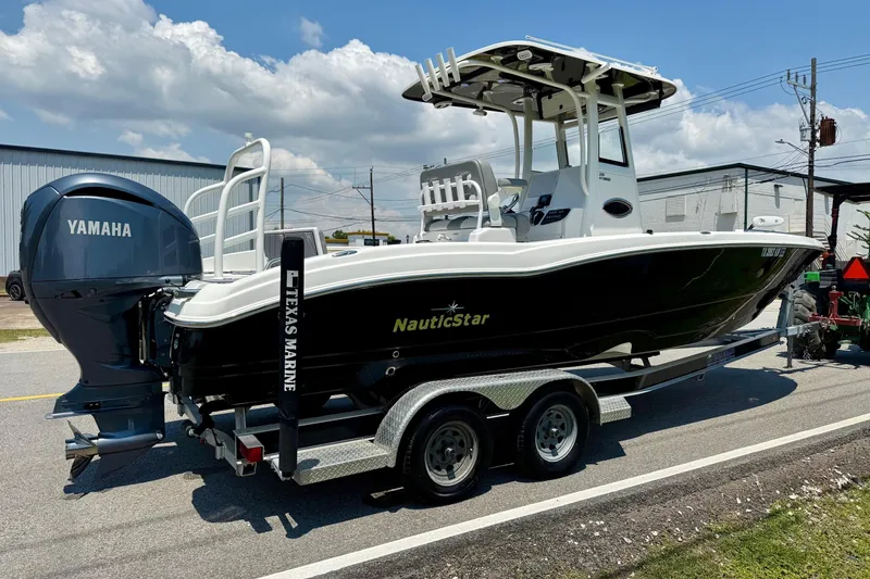Slide: The Image of 2022 NauticStar 251 Hybrid boat on trailer with Yamaha engine, parked outdoors. - 4