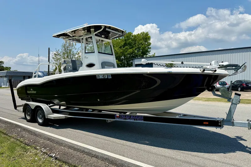 Slide: The Image of 2022 NauticStar 251 Hybrid boat on trailer, parked outdoors under blue sky. - 5