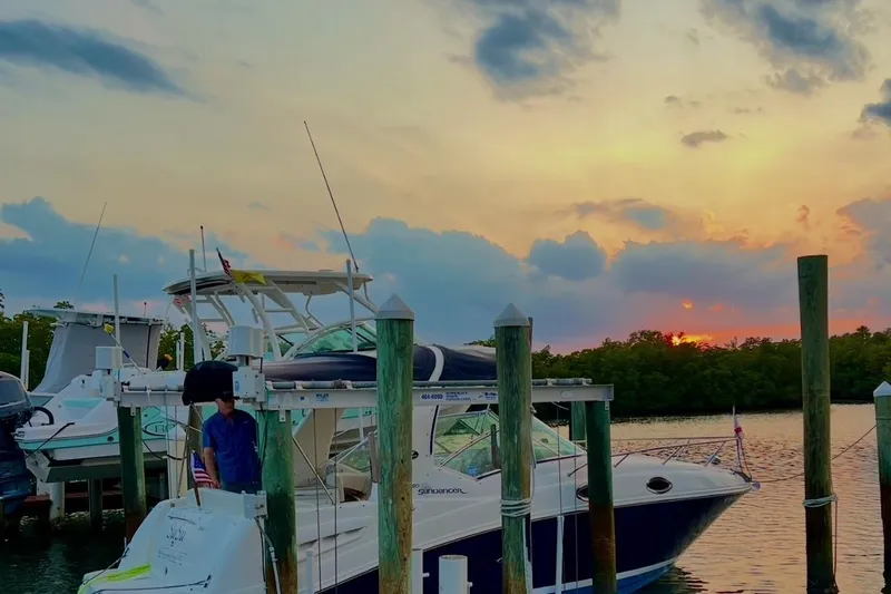 Slide: The Image of 2005 Sea Ray 260 Sundancer docked at sunset, serene waterfront view. - 15