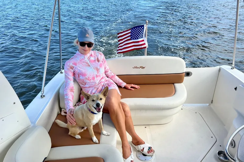 Slide: The Image of Woman and dog relaxing on 2005 Sea Ray 260 Sundancer boat with American flag. - 16