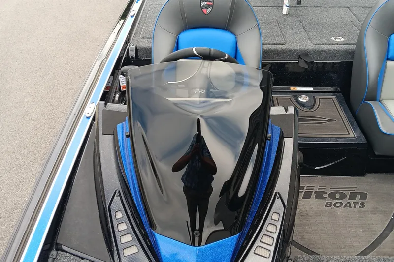 Slide: The Image of 2025 Triton 20XP boat interior with blue and black seating and sleek dashboard design. - 11
