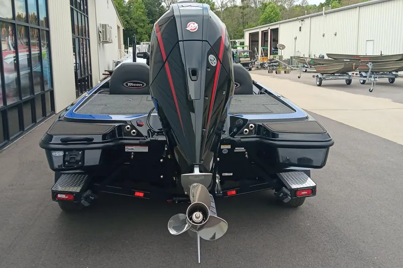 Slide: The Image of 2025 Triton 20XP boat with powerful outboard motor, parked outside a showroom. - 3