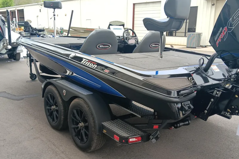 Slide: The Image of 2025 Triton 20XP boat with dual axle trailer, parked outdoors. - 4