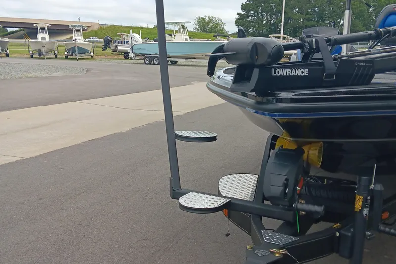 Slide: The Image of 2025 Triton 20XP boat with Lowrance equipment at a marina, surrounded by other boats. - 8