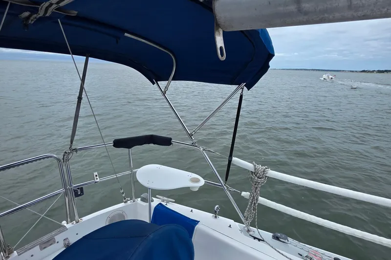Slide: The Image of 1987 Catalina 30 MkII sailboat cockpit with blue canopy on calm waters. - 12