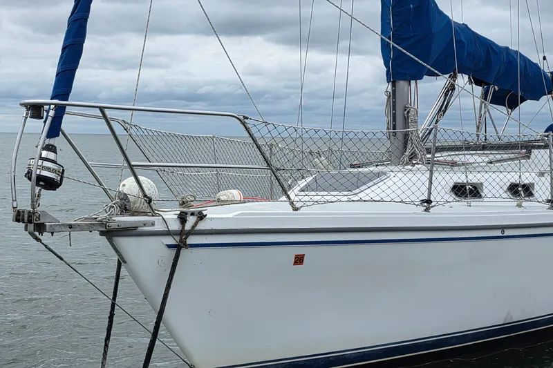 Slide: The Image of 1987 Catalina 30 MkII sailboat with blue sail cover on calm water. - 2