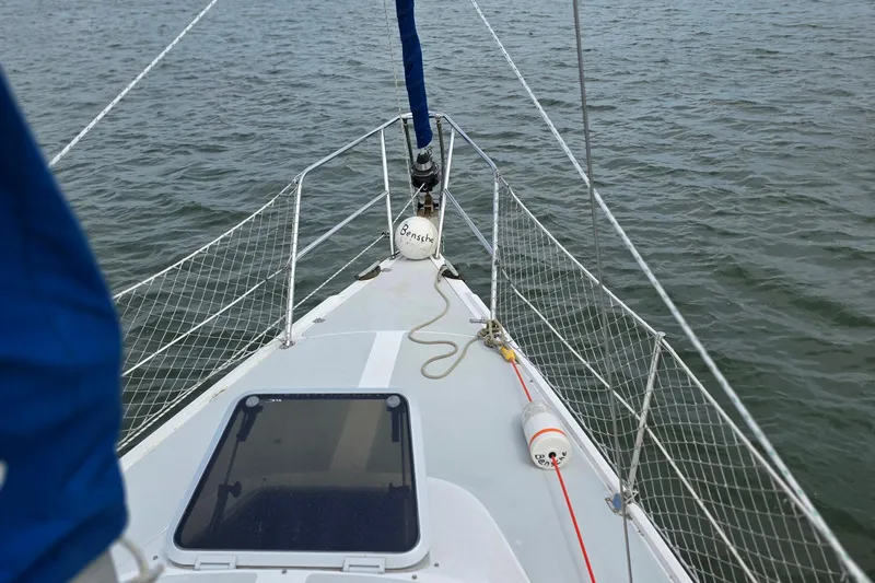 Slide: The Image of 1987 Catalina 30 MkII sailboat deck with safety netting on calm water. - 7