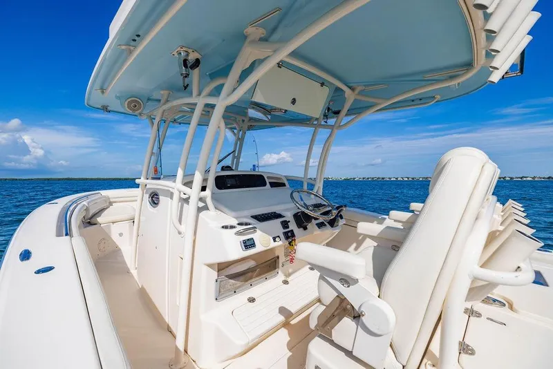 Slide: The Image of 2016 Grady-White Canyon 336 boat interior with helm, ocean view, and clear blue sky. - 17