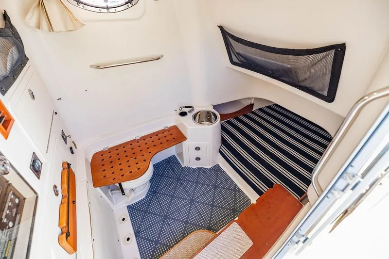 Slide: The Image of 2016 Grady-White Canyon 336 cabin interior with seating and striped flooring. - 18