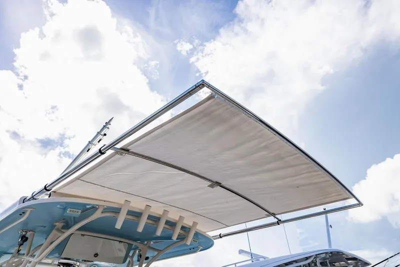 Slide: The Image of 2016 Grady-White Canyon 336 boat canopy against a bright, cloudy sky. - 20