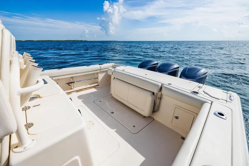 Slide: The Image of 2016 Grady-White Canyon 336 boat on open water, featuring spacious deck and triple engines. - 4