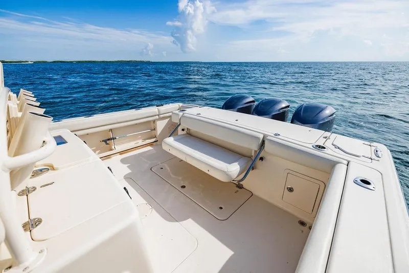 Slide: The Image of 2016 Grady-White Canyon 336 boat on open water, featuring spacious deck and triple engines. - 6
