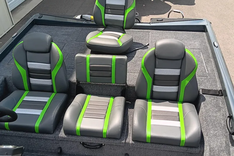 Slide: The Image of 2025 Ranger RT188P boat seats with green and gray accents, arranged on a carpeted deck. - 13