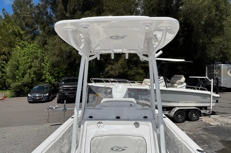 Slide: The Image of 2025 Glasstream 240 CCX boat with T-top, parked outdoors near trees and vehicles. - 11