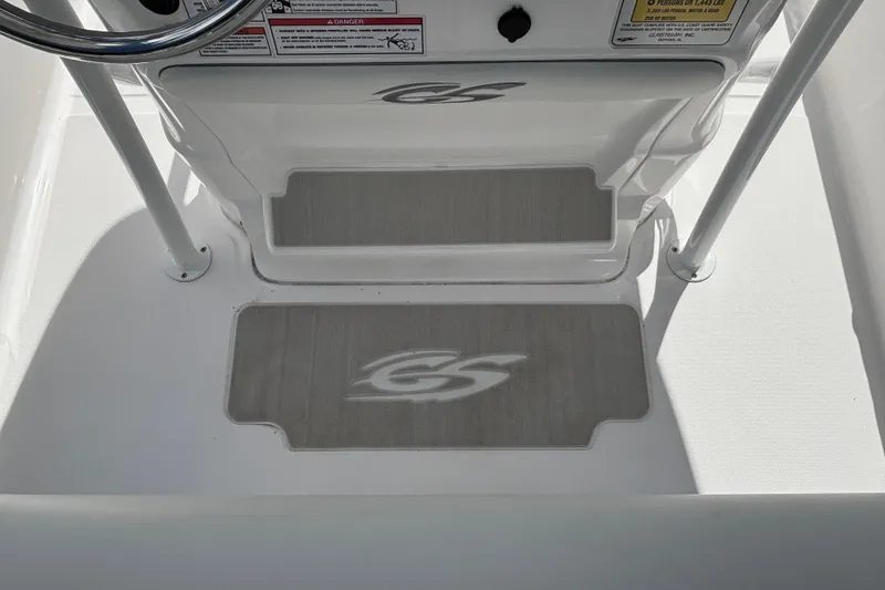 Slide: The Image of 2025 Glasstream 240 CCX boat interior with steering wheel and branded floor mats. - 16