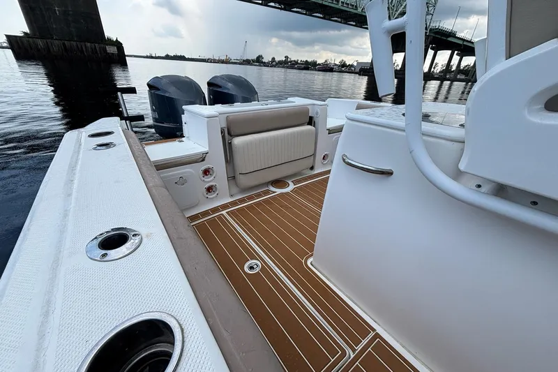 Slide: The Image of 2016 Sea Fox 286 boat interior with teak flooring and dual engines under a bridge. - 14