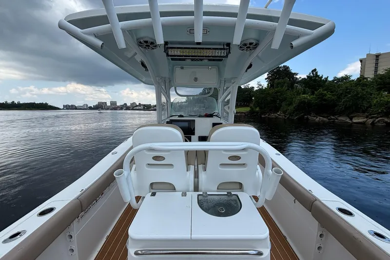 Slide: The Image of 2016 Sea Fox 286 boat interior with seating, on a calm river under cloudy skies. - 17