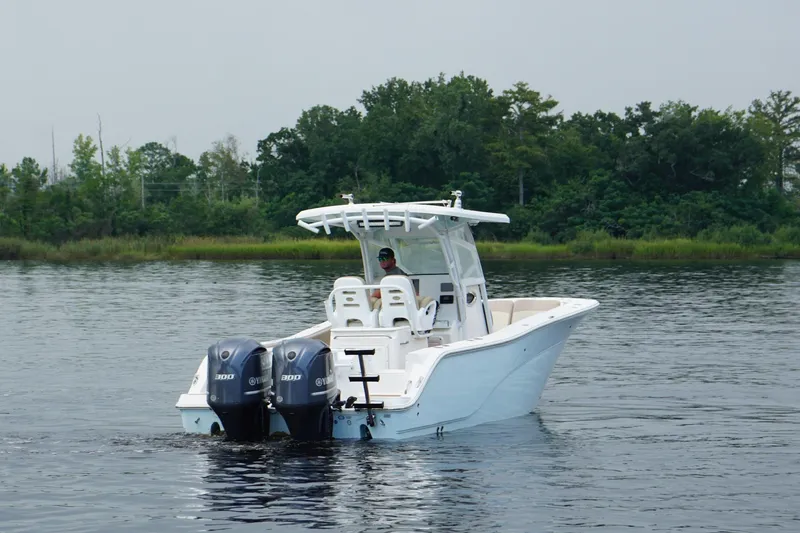 Slide: The Image of 2016 Sea Fox 286 boat with dual engines on calm water, surrounded by lush greenery. - 23