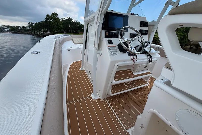 Slide: The Image of 2016 Sea Fox 286 boat interior with steering console and wooden deck flooring. - 28