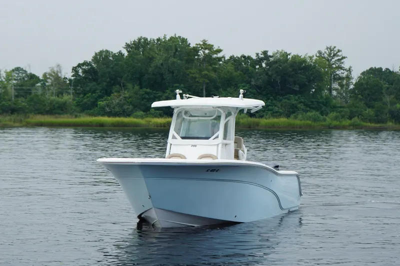 Slide: The Image of 2016 Sea Fox 286 boat on calm water with lush green background. - 29