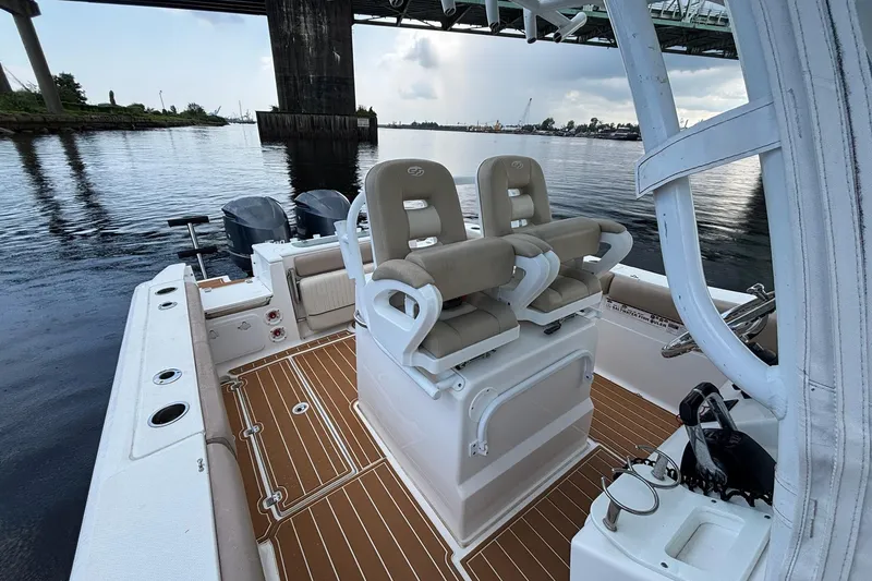 Slide: The Image of 2016 Sea Fox 286 boat interior with dual seats, under a bridge on calm water. - 9