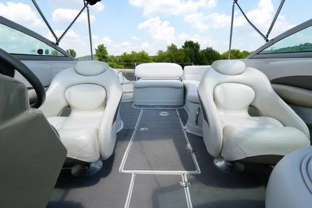 Slide: The Image of 2006 Crownline 252 EX boat interior with plush seating and open deck under blue sky. - 10