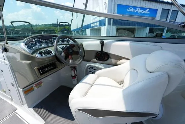 Slide: The Image of Interior of 2006 Crownline 252 EX boat with steering wheel and white seating. - 11