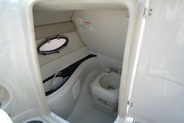 Slide: The Image of 2006 Crownline 252 EX boat interior with compact bathroom and porthole window. - 14