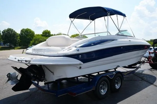 Slide: The Image of 2006 Crownline 252 EX boat on trailer with blue canopy, parked outdoors. - 3