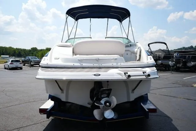 Slide: The Image of 2006 Crownline 252 EX boat with canopy, parked on asphalt under a cloudy sky. - 4